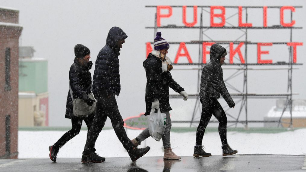 FILE - Pedestrians walk near Pike Place Market as snow falls Monday, Feb. 11, 2019, in downtown Seattle. (AP Photo/Ted S. Warren)