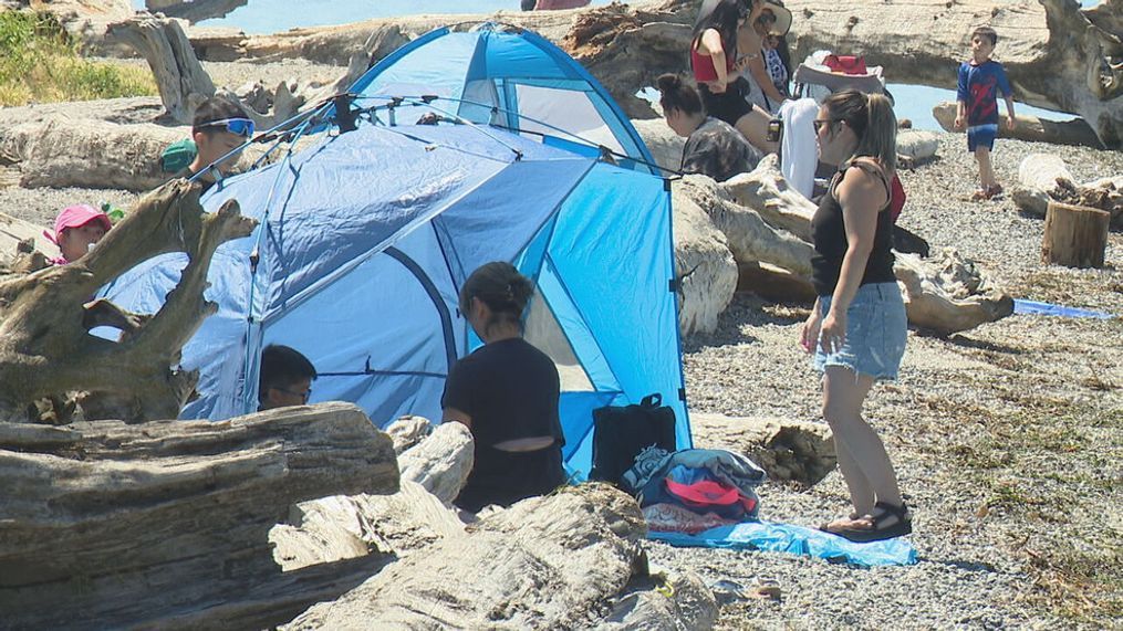 FILE – People sit along the beach at Lighthouse Park in Mukilteo on Monday, July 8, 2024. (KOMO News)