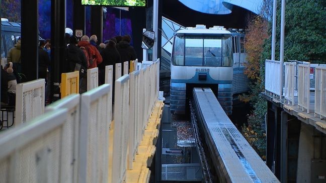 Passengers wait in line as the Seattle Monorail pulls into the Seattle Center station. (KOMO News)
